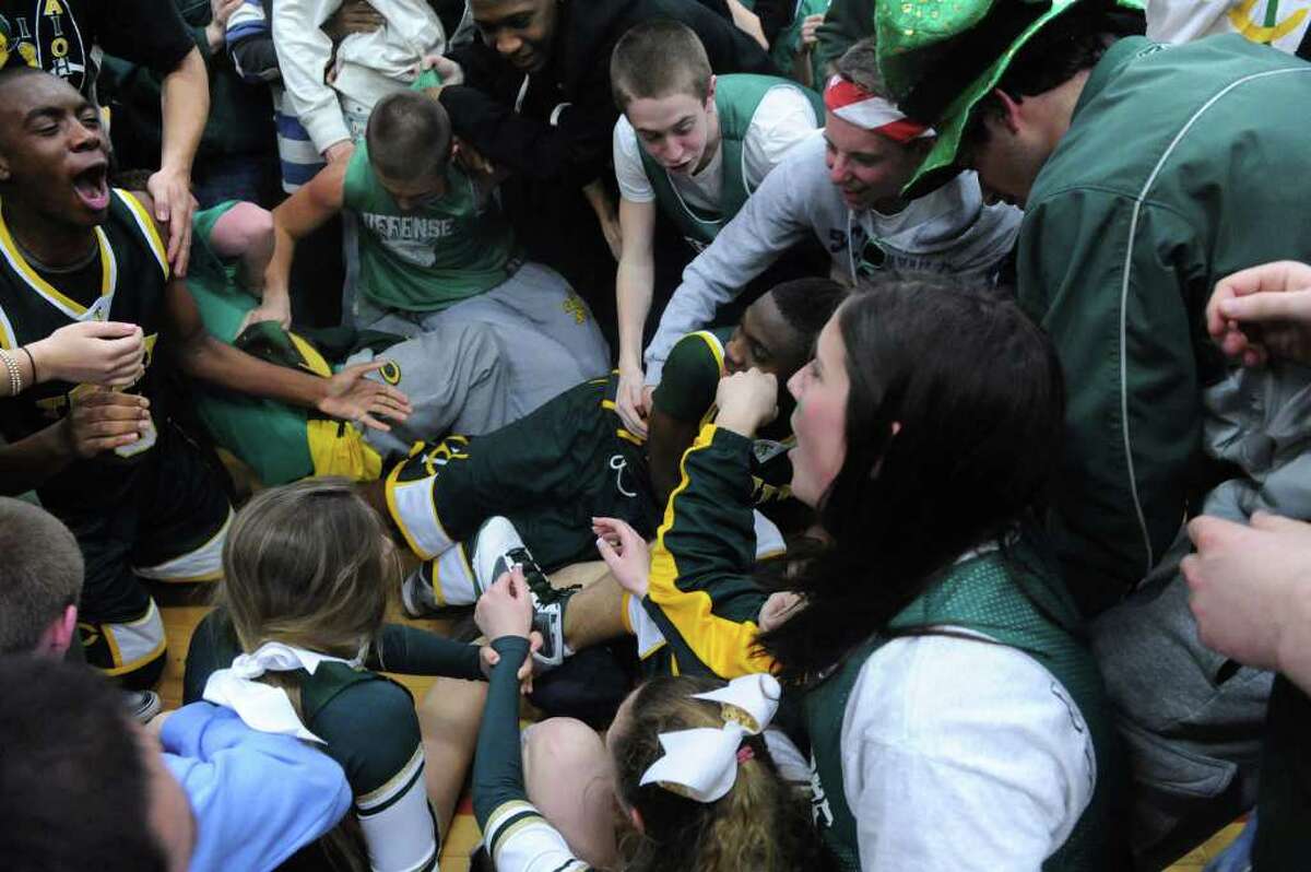 Trinity Catholic fans and players celebrate the team's win in overtime over Notre Dame-Fairfield in the Class M semifinals at Masuk High School in Monroe, Conn., March 15, 2011. Trinity won 62-59.