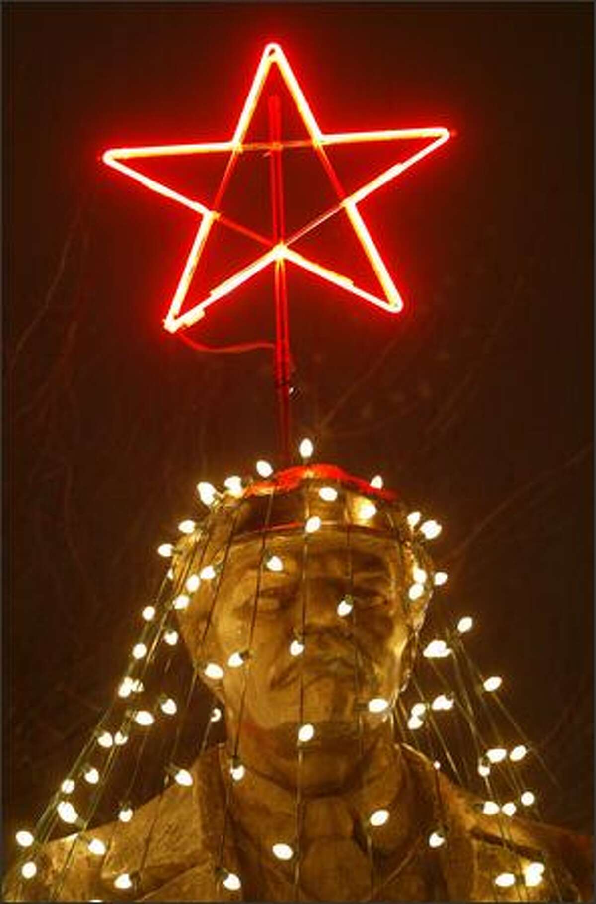 Folks in Fremont gathered last night for the lighting ceremony at the Lenin statue. Strings of light created a Christmas tree around the statue, complete with a shining red star on his hat.