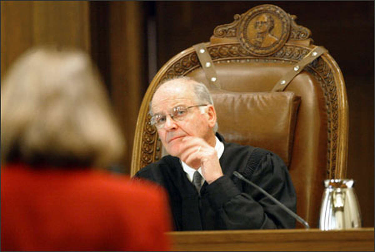 State Supreme Court Justice Gerry Alexander listens to Janine Joly, of the King County elections division, during the hearing about disputed ballots.
