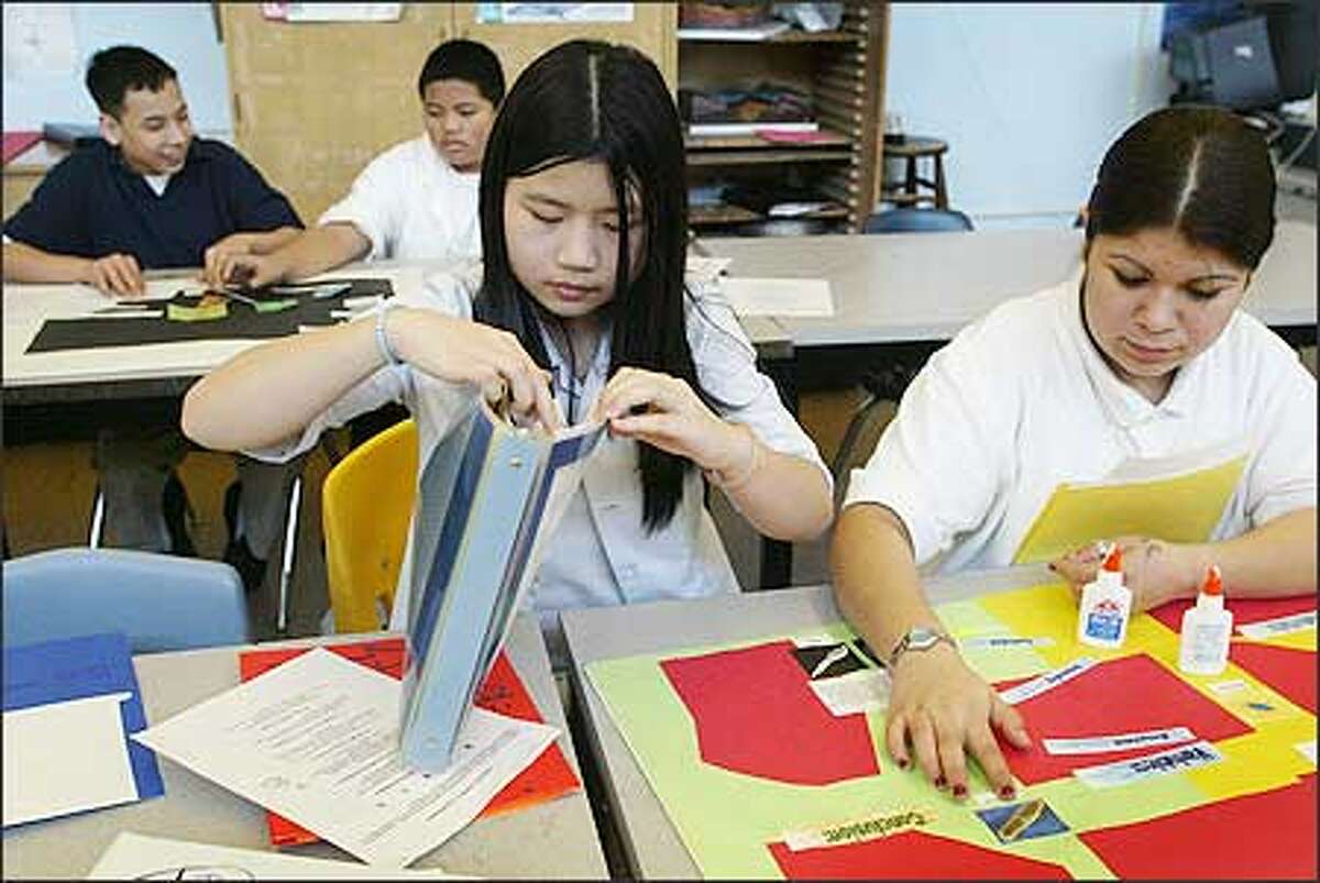 Meany Middle School eighth-graders Ving Hoang, left, and Carolina Fernandez work on a science project recently. The school has only 464 students and hasn't been renovated since it was built in 1955, two factors that make it vulnerable in light of possible closures starting in 2006-07.