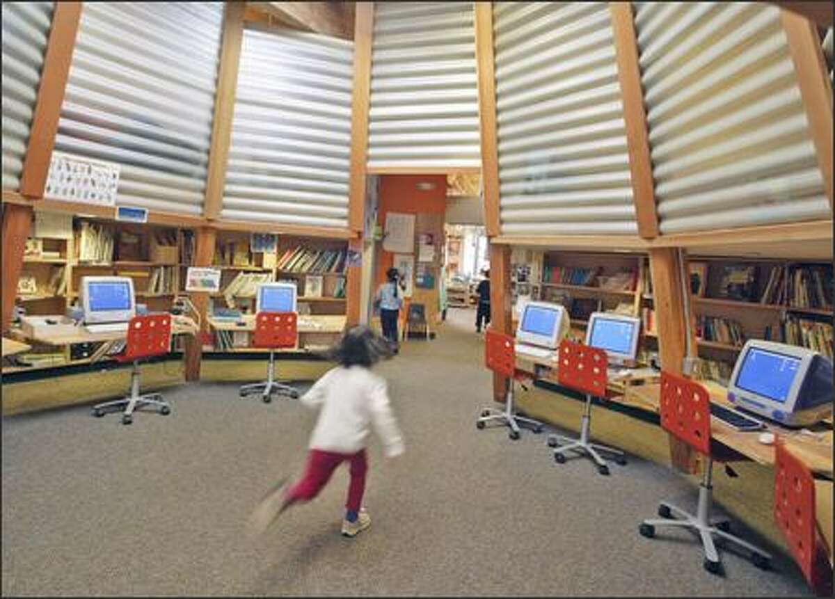 In a blur, 4-year-old Marika Inouye dashes through the lampshade- shaped computer and library room in the University Child Development School's "Labyrinth" building.