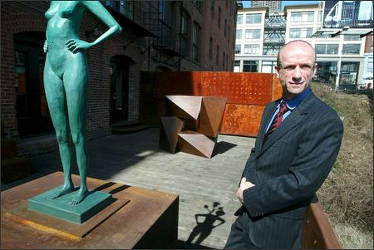 Pioneer Square galleries help each another, says Greg Kucera, seen on the deck of his gallery with sculptures by John Buck and Peter Millett (background). "The success of one helps everybody."
