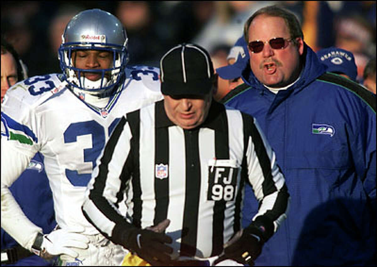 Seahawks coach Mike Holmgren has a mouthful for field judge Bill Lovett after Darryl Williams (left) was called for pass interference at the end of the second quarter.