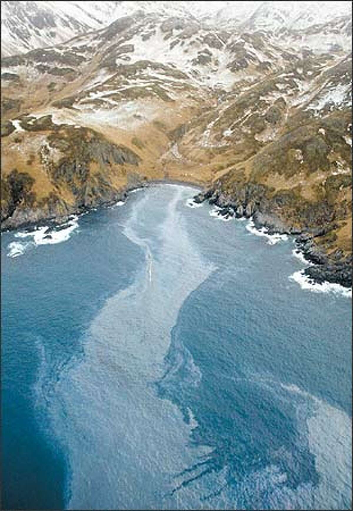 A fuel oil sheen from the Selendang Ayu wreck is seen coating the pristine coastline of the island of Unalaska.