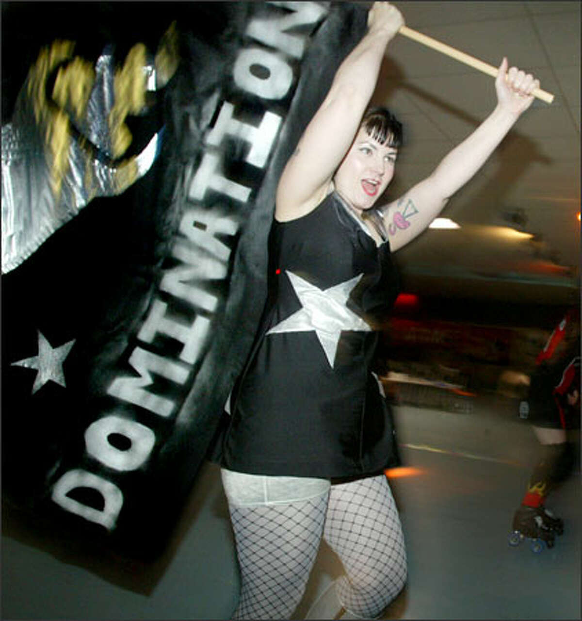 Krista "Betty Ford Galaxy" LaFontaine of the Throttle Rockets circles the rink with a flag reading "intergalactic domination."