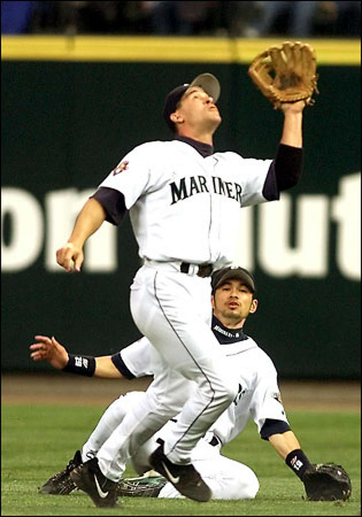 Ichiro Suzuki, below, barely avoids a collision with second baseman Bret Boone, who came down with the pop fly hit by Ryan Klesko in the sixth inning of Friday's game against San Diego.