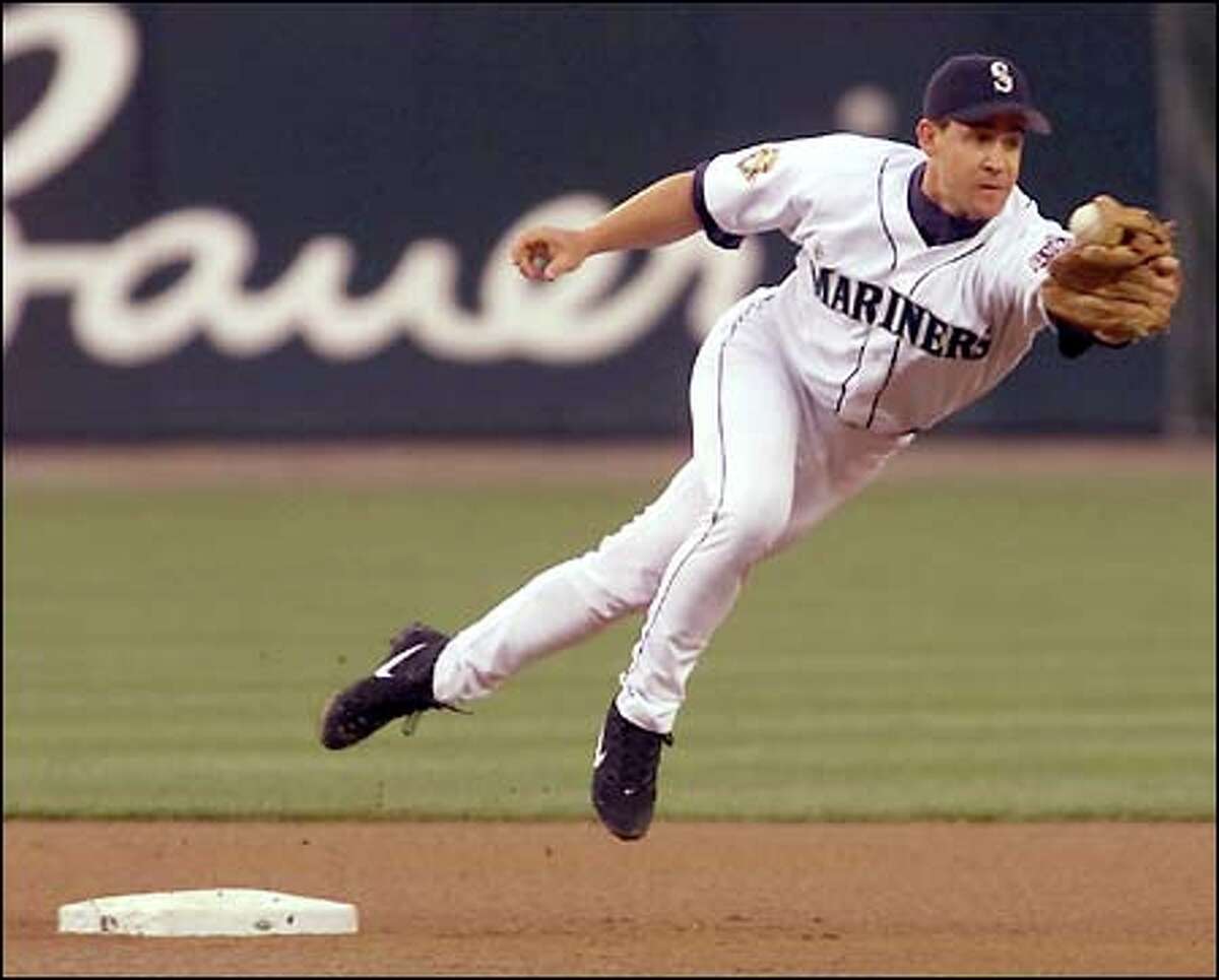 Mariners second baseman Bret Boone is pulled off the bag on a throwing error by third baseman David Bell in the fourth inning. The error helped the Giants score two unearned runs.
