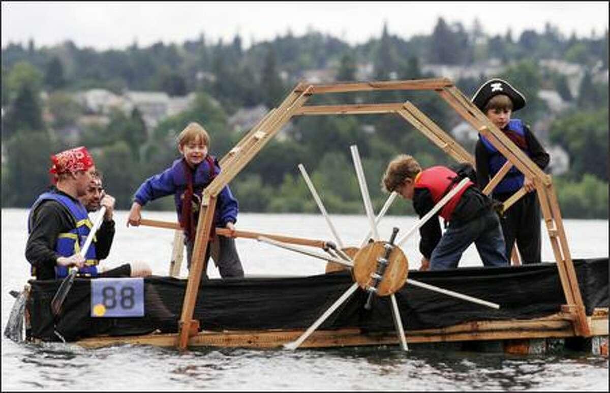 Torben Christiansen, left, Richard Seroussi, left back, and their sons Andrew Christiansen, 7, left center, Daniel Seroussi, 8, right center, and Jacob Christiansen, 9, right, man the "Pirates of the Cheese-Cutters" milk carton float at the first day of Seafair's Milk Carton Derby at Green Lake.