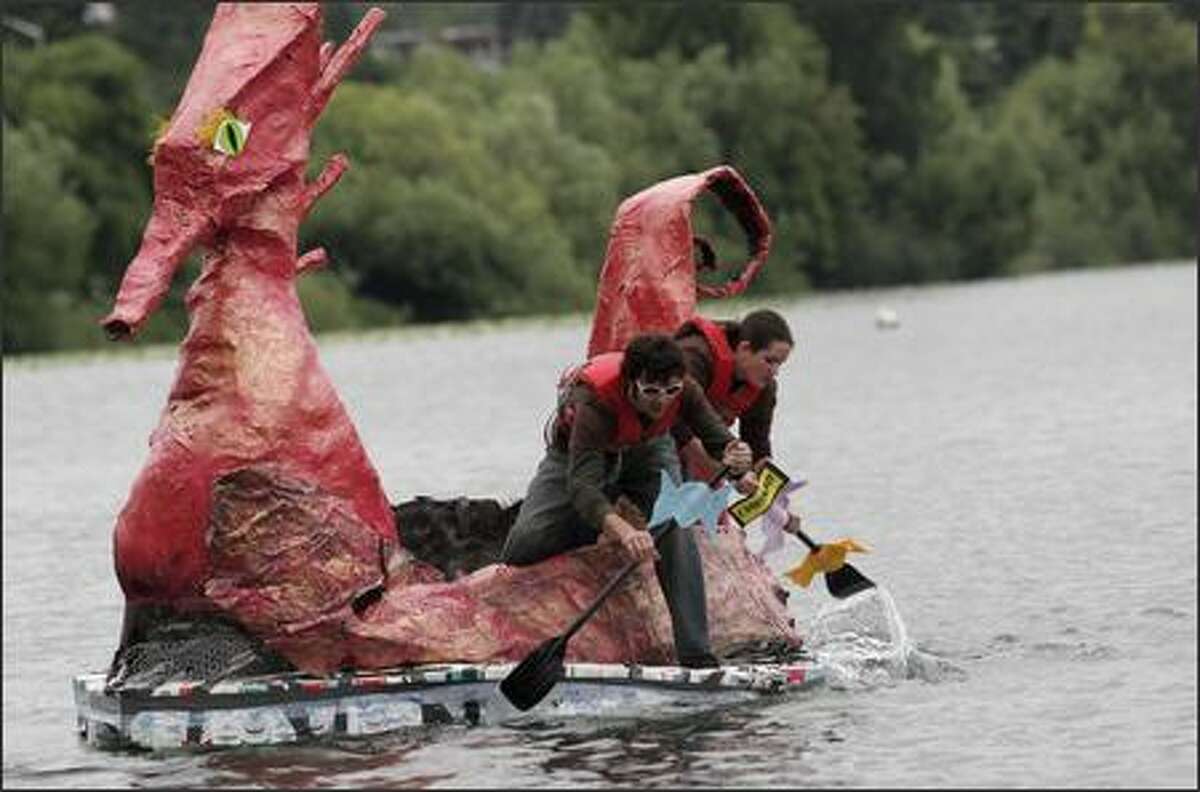 Gareth Mccammon, left, and Jennifer Lehnert, right, paddle towards the starting line for the '14 years and older' open race at the Seafair Milk Carton Derby in their Charlie and the Chocolate Factory inspired "Shnoozeberry Contraption" on Green Lake on Saturday.