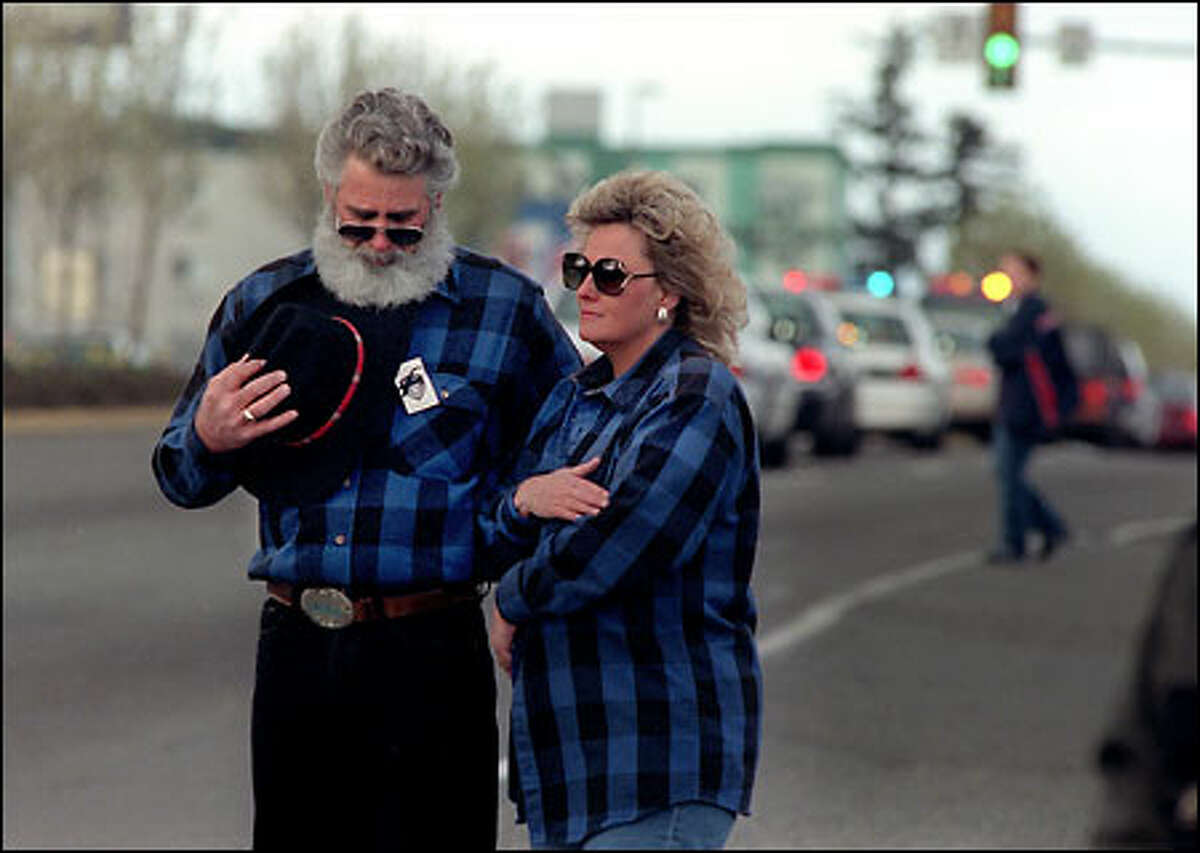 Michael and Jesse Farnsworth cover their hearts and bow their heads as the funeral procession for Steven Underwood passes by on Pacific Highway South. The Farnsworths live in Des Moines and had seen Underwood around town many times.