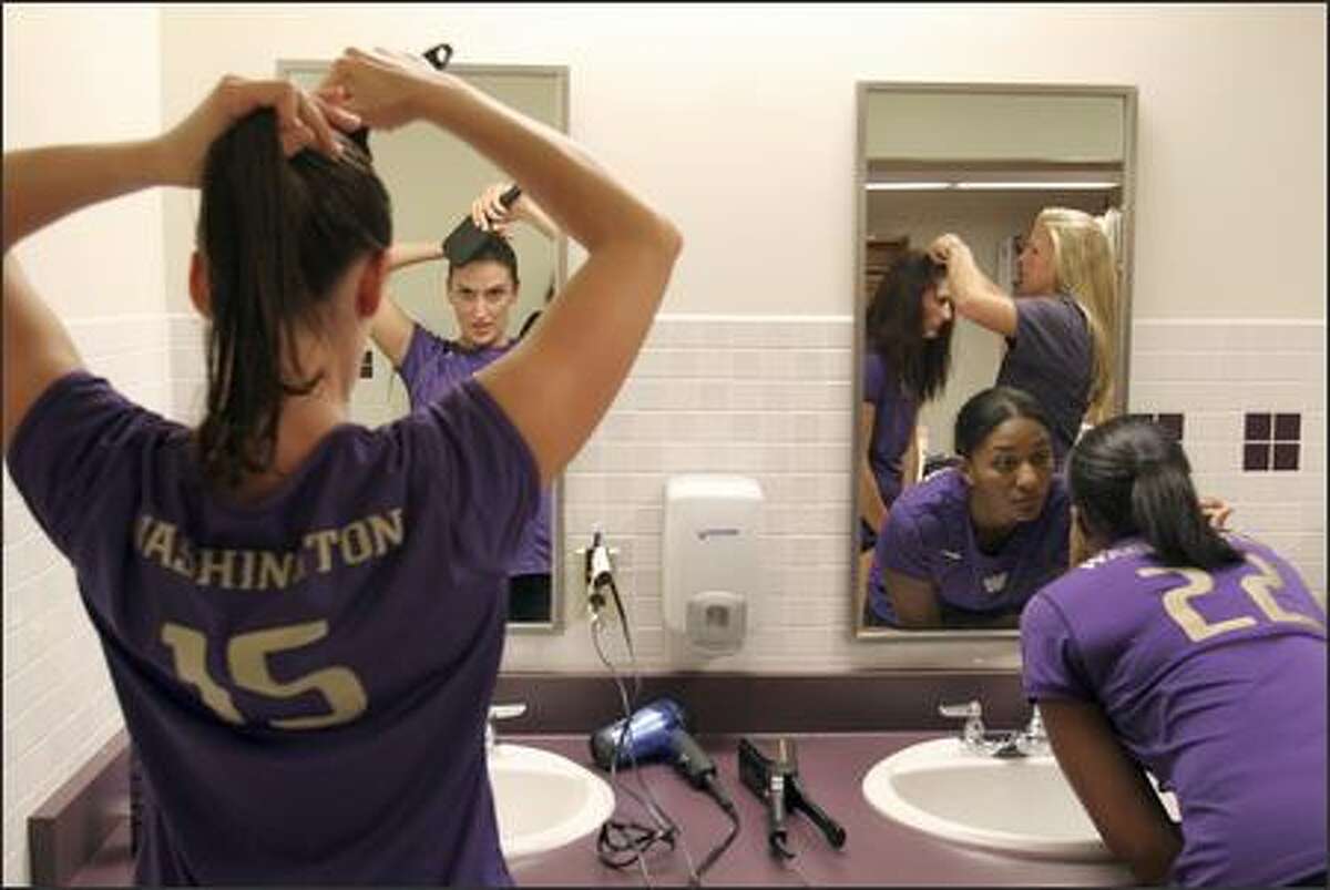 Danka Danicic, left, and Jill Collymore, right, get ready for a Fox Sports Network broadcast game against UCLA in their locker room at UW. In the mirror are seniors Brie Hagerty, left, and Jessica Veris, right. Danicic is a defensive specialist from Serbia & Montenegro.