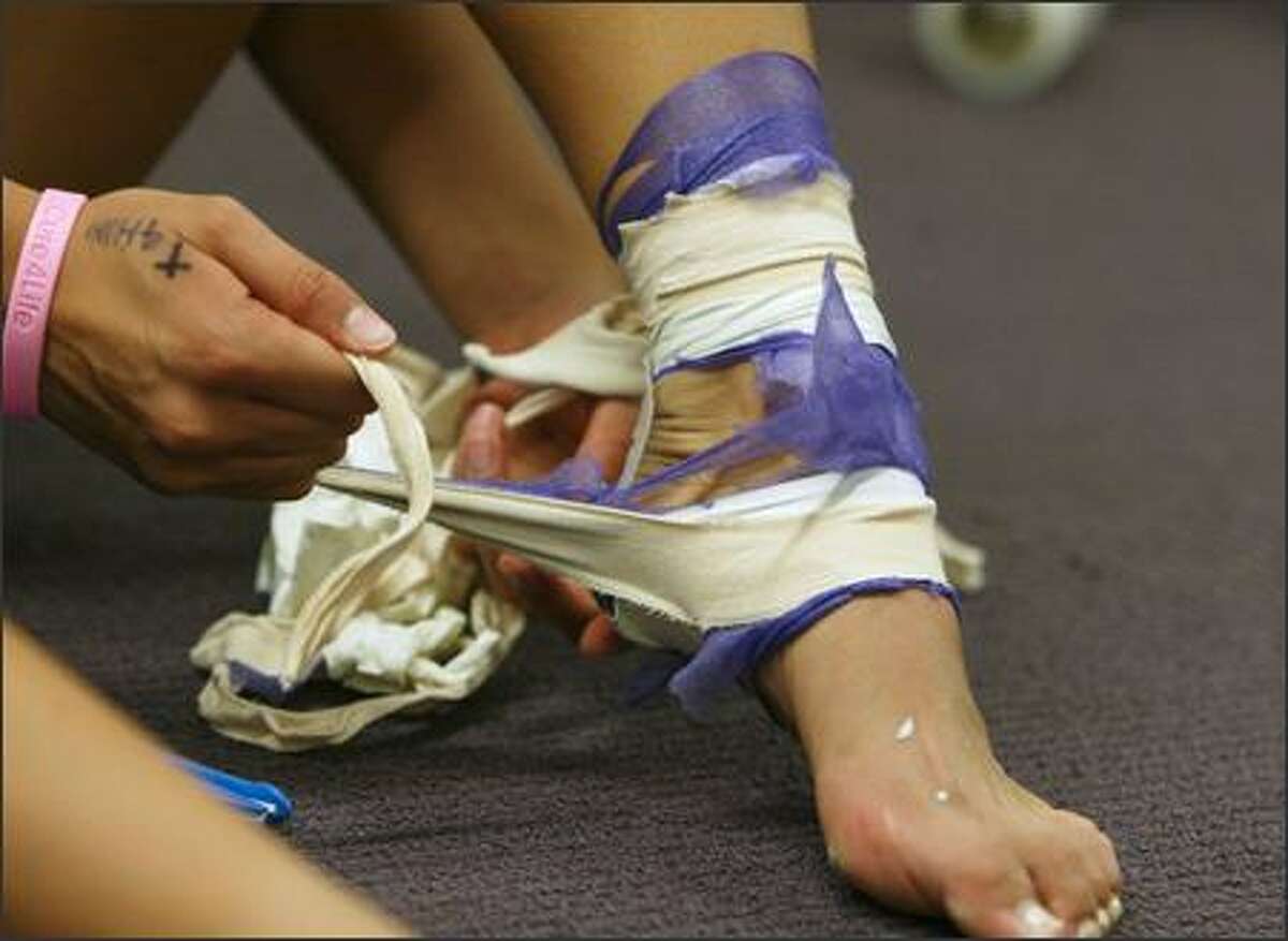Candace Lee unwraps her taped ankle after UW beat the UCLA Bruins 3-0 in Seattle on October 13, 2005.