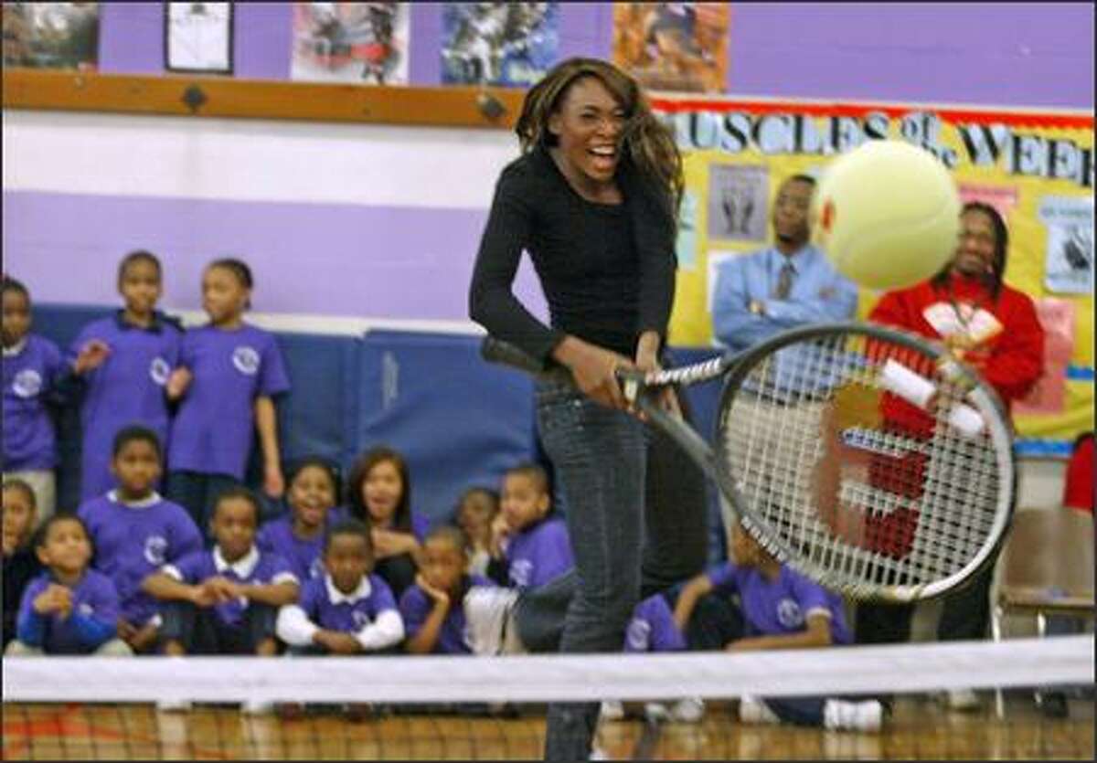 Venus Williams plays tennis with a giant-sized tennis racquet at T.T. Minor Elementary School in Seattle. The Williams sisters are visiting Seattle as part of a three-city tour.