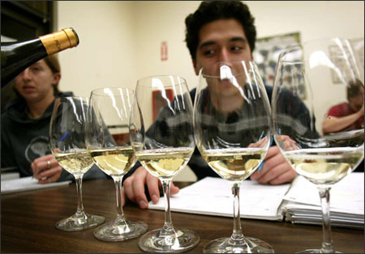 Student Abram Geballe inspects glasses of wine at South Seattle Community College's Northwest Wine Academy, where students can earn certificates in winemaking and marketing.