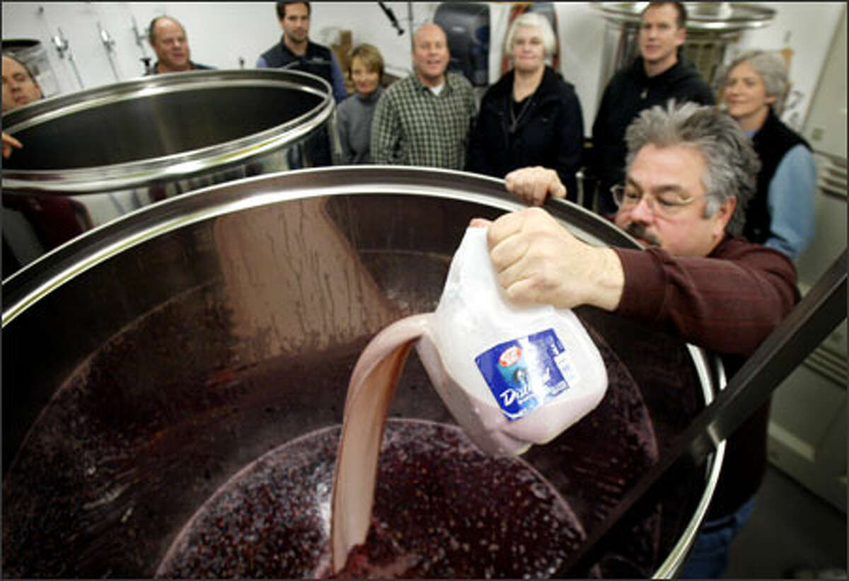 Instructor Peter Bos pours in the yeast to activate the wine during a winemaking class at the Northwest Wine Academy at South Seattle Community College.