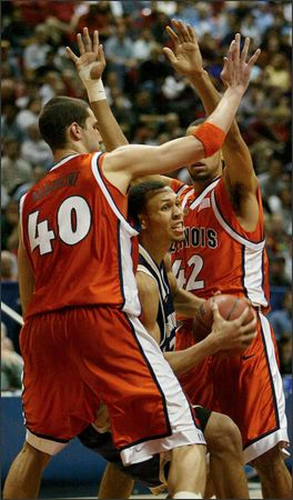 UW's Brandon Roy drives between Illinois' James Augustine (40) and Brian Randle to score two of his game high 21 points, and tie the score at 60 late in the second half.