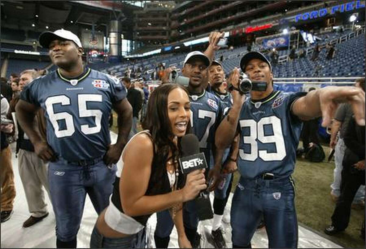 Melyssa Ford of BET Network has little problem getting the attention of Seahawks players, from left, Chris Spencer, Jordan Babineaux and Josh Scobey during Super Bowl Media Day on Tuesday.
