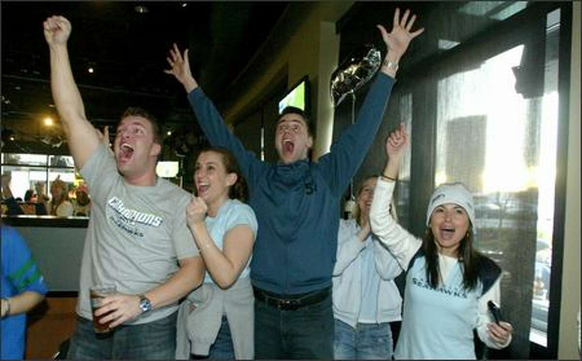 Seahawks fans, from left, Jon Wilmonth, Alicia Scalzo, Steve Francis, Vicky Francis, and Dangle Moore celebrate during first-half action as they watch the Super Bowl at Sport Restaurant and Bar in Fisher Plaza.