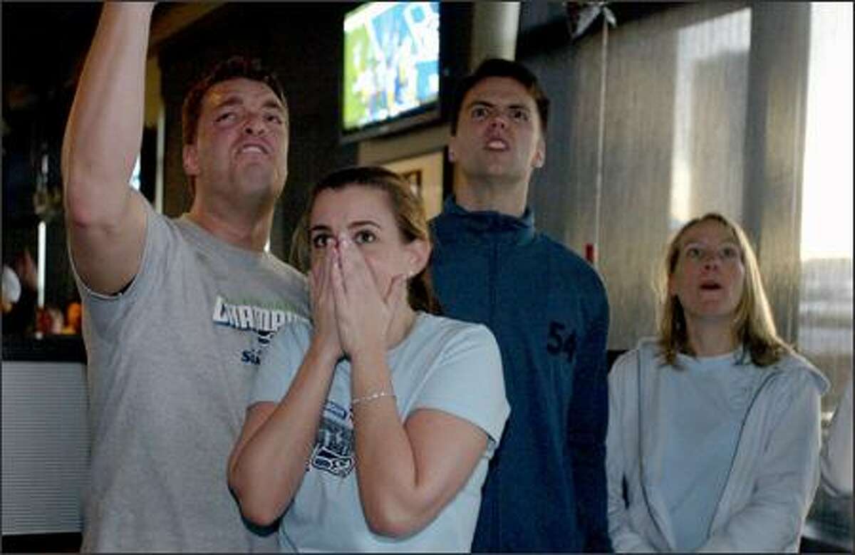 Seahawks fans, from left, Jon Wilmonth, Alicia Scalzo, Steve Francis and Vicky Francis celebrate during first-half action as they watch the Super Bowl at Sport Restaurant and Bar in Fisher Plaza.