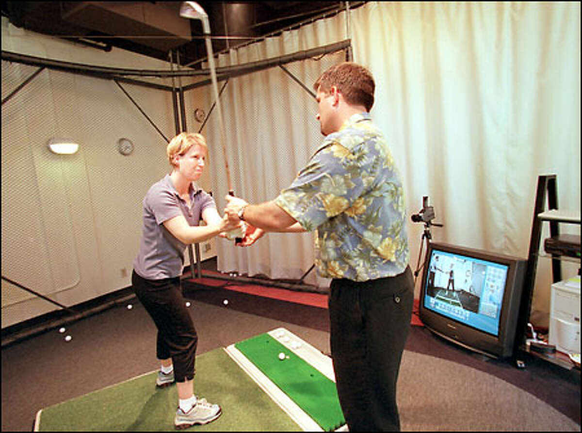 Lisa Beckman of Seattle receives a lesson from Bogart Golf teaching professional Dennis Stone.