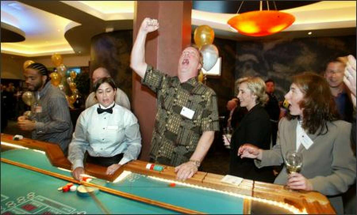 KJR Sports Radio talk show host Dave Grosby lets out a roar at the craps table as FSN's Angie Mentink, to Grosby's left, smiles at his antics.