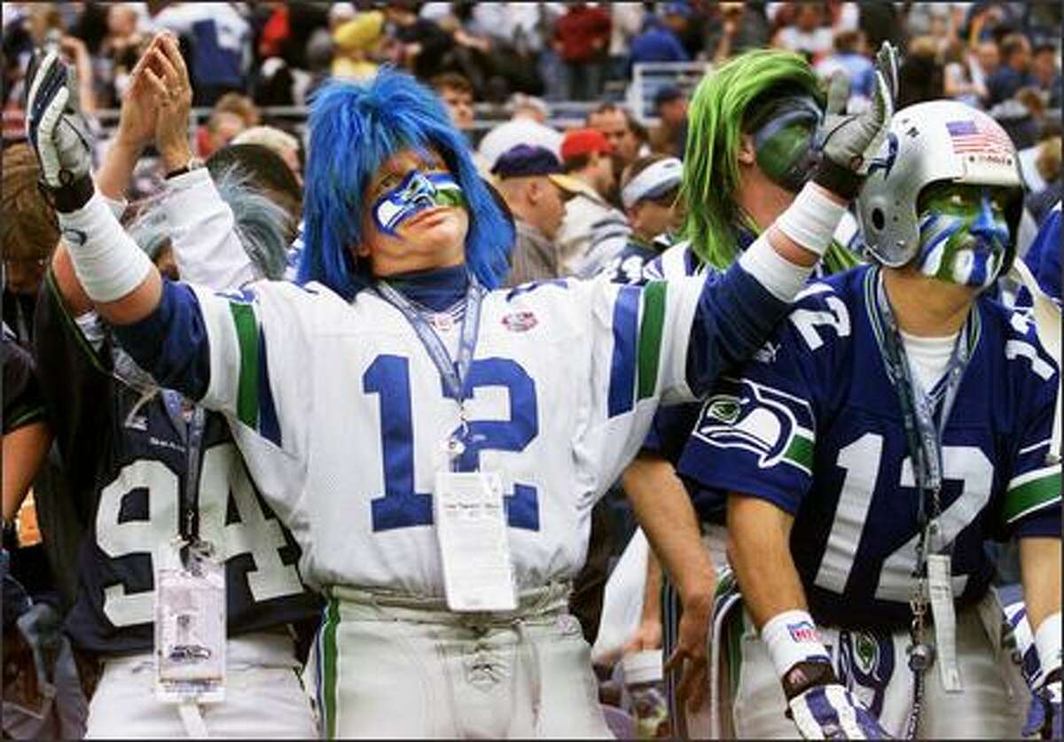 Seahawks fans Jeff Schumaier, or Mr. Seahawk (left), and Brad "Cannonball Man" Carter react to a play at Seahawks Stadium.