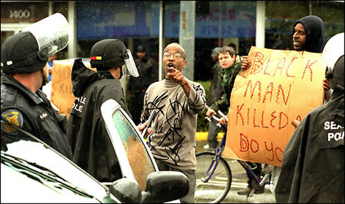 A man confronts Seattle police on 23rd Avenue East and East Union Street Friday during a protest following the shooting death of Aaron Roberts late Thursday night.