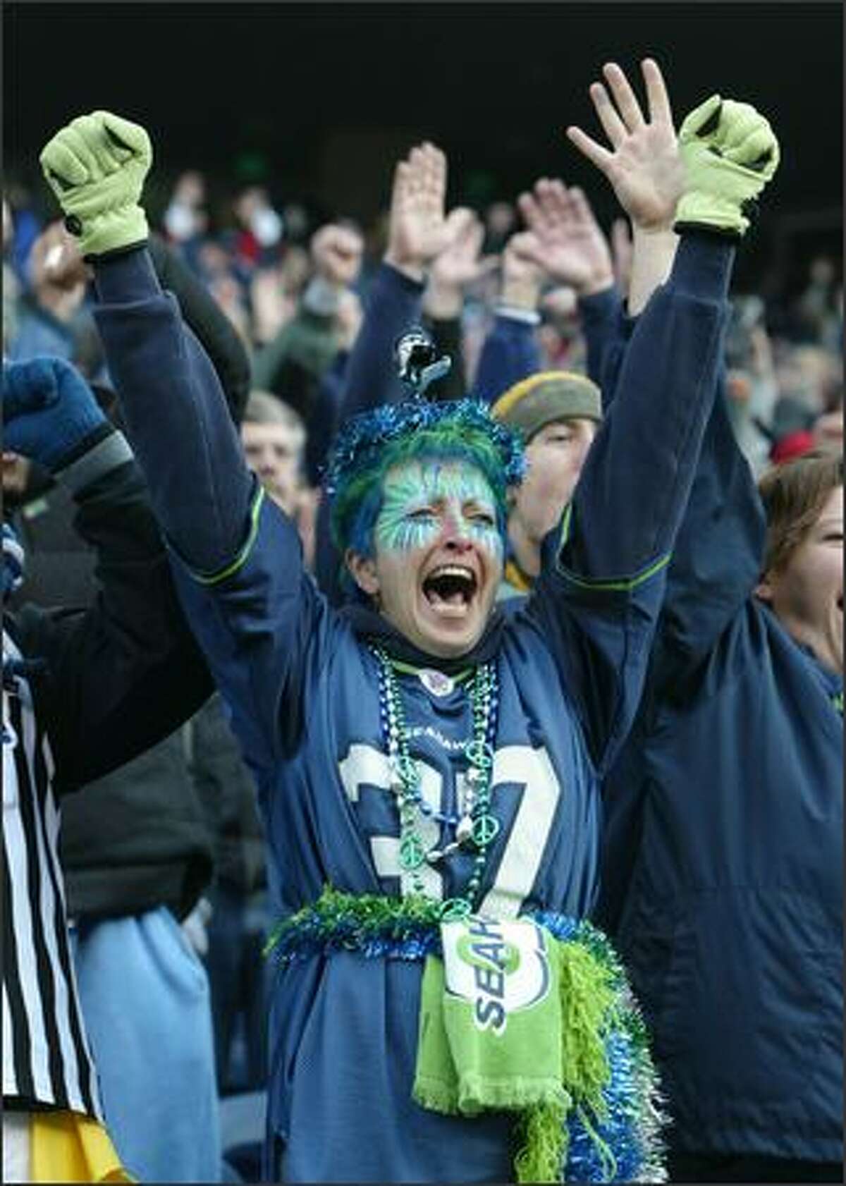 Margy Wick, who came all the way from Soap Lake in Eastern Washington to cheer for the Seahawks in Sunday's game against the San Francisco 49ers at Qwest Field, signals touchdown after a Seattle score in the first quarter.
