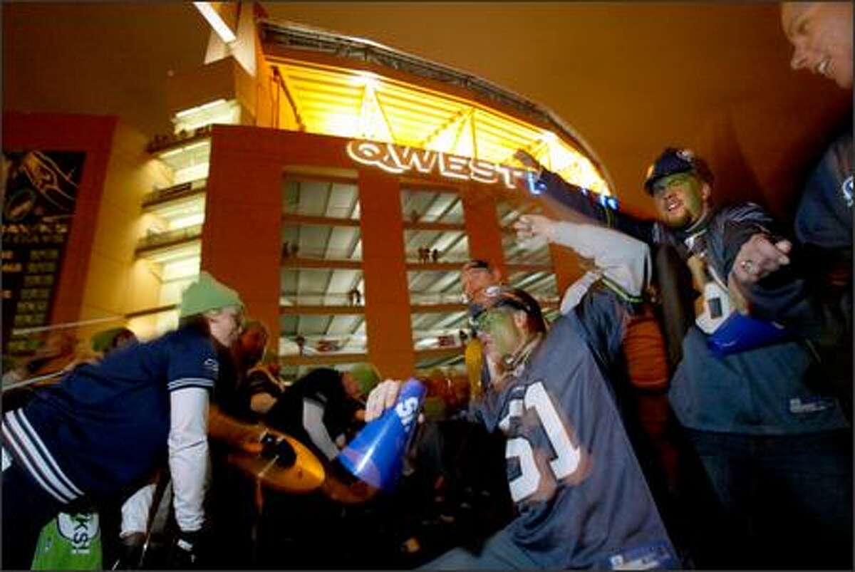 Jim Lussier of Everett, center, dances with members of Blue Thunder outside Qwest Field after the game.
