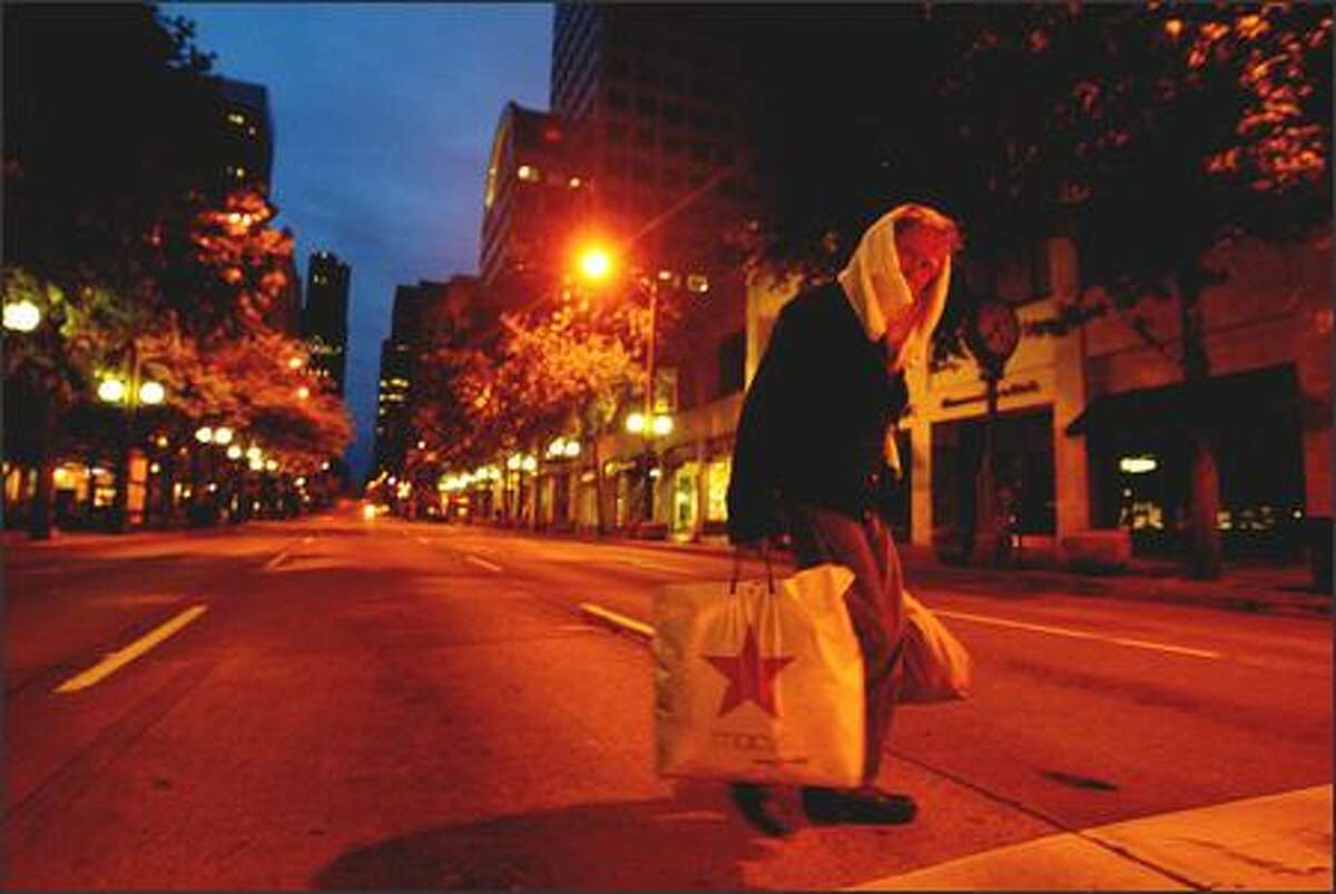 4:35 a.m. –- With the first light of the longest day of the year, a homeless man crosses Third Avenue at Westlake Park on Wednesday.