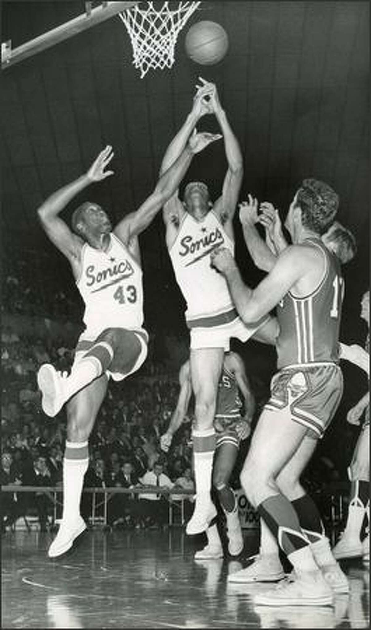 1967: Seattle Supersonics players Plummer Lott and Bob Rule go for a rebound against Chicago.