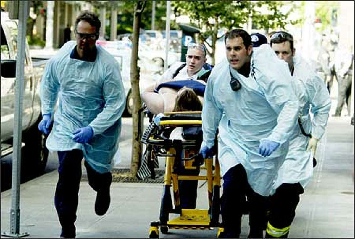 Paramedics rush away one of the six victims of a shooting at the Jewish Federation of Greater Seattle's offices downtown on Friday. One victim died, and five more -- all women -- were wounded.