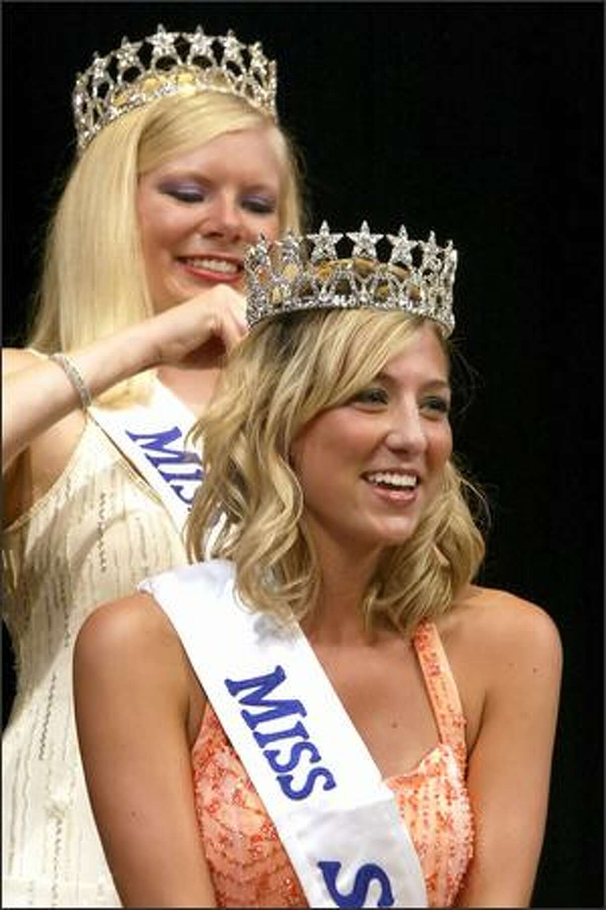 New Miss Seafair Erin Waid, front, is all smiles as she is crowned by former Seafair Queen Melissa Parks during the Coronation Tuesday in Seattle.