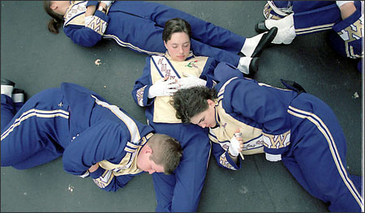 Members of the University of Washington marching band take a moment to rest before the game.