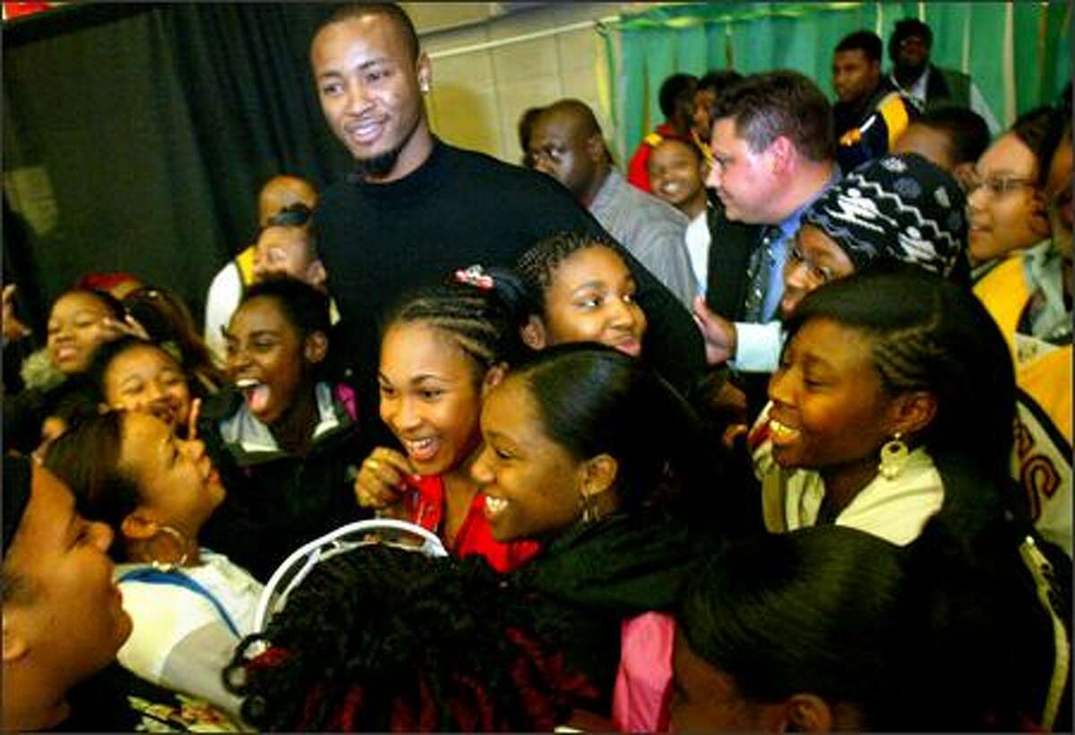 Seattle SuperSonics player Rashard Lewis is swarmed by teenagers after he appeared at Cleveland High School in West Seattle on Friday. Ray Allen and Rashard Lewis will be replacing the boys basketball team's equipment at Cleveland High School, which was stolen earlier this month. Allen's Ray of Hope Foundation and Lewis' Rashard Lewis Foundation, along with the Sonics and Storm Foundation, will also present the school with a monetary donation to help the basketball team this season.