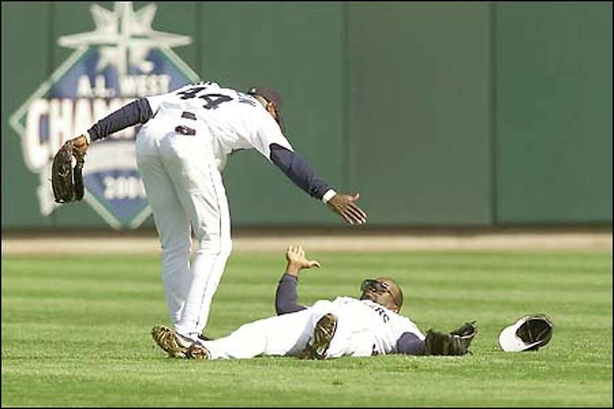 Center fielder Mike Cameron offers shortstop Mark McLemore a hand up after McLemore made a diving catch in the second.