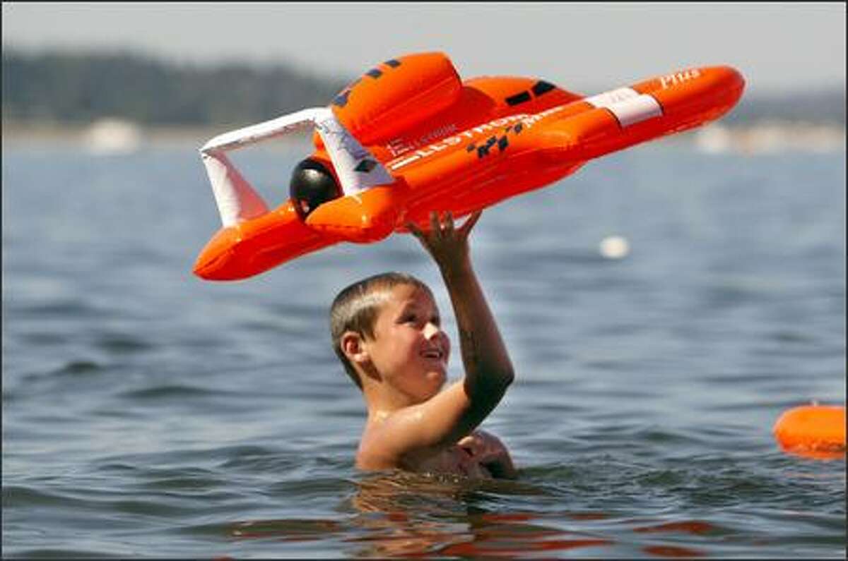 Tim Allen, 8, from Mossyrock, plays with his inflatable hydroplane in Lake Washington.
