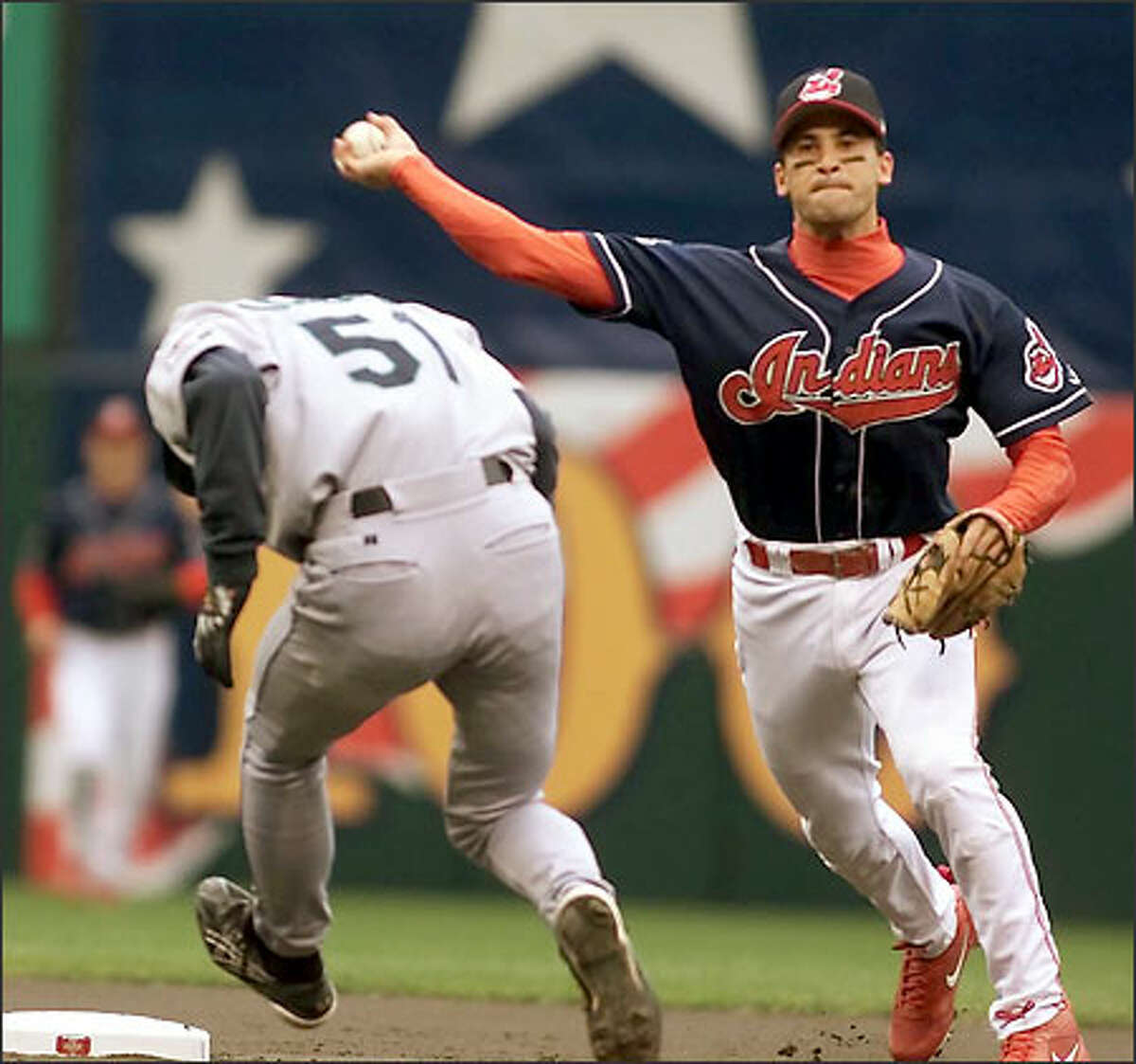 Ichiro ducks but is out at second as Cleveland shortstop Omar Vizquel turns the double play in the first inning of play.