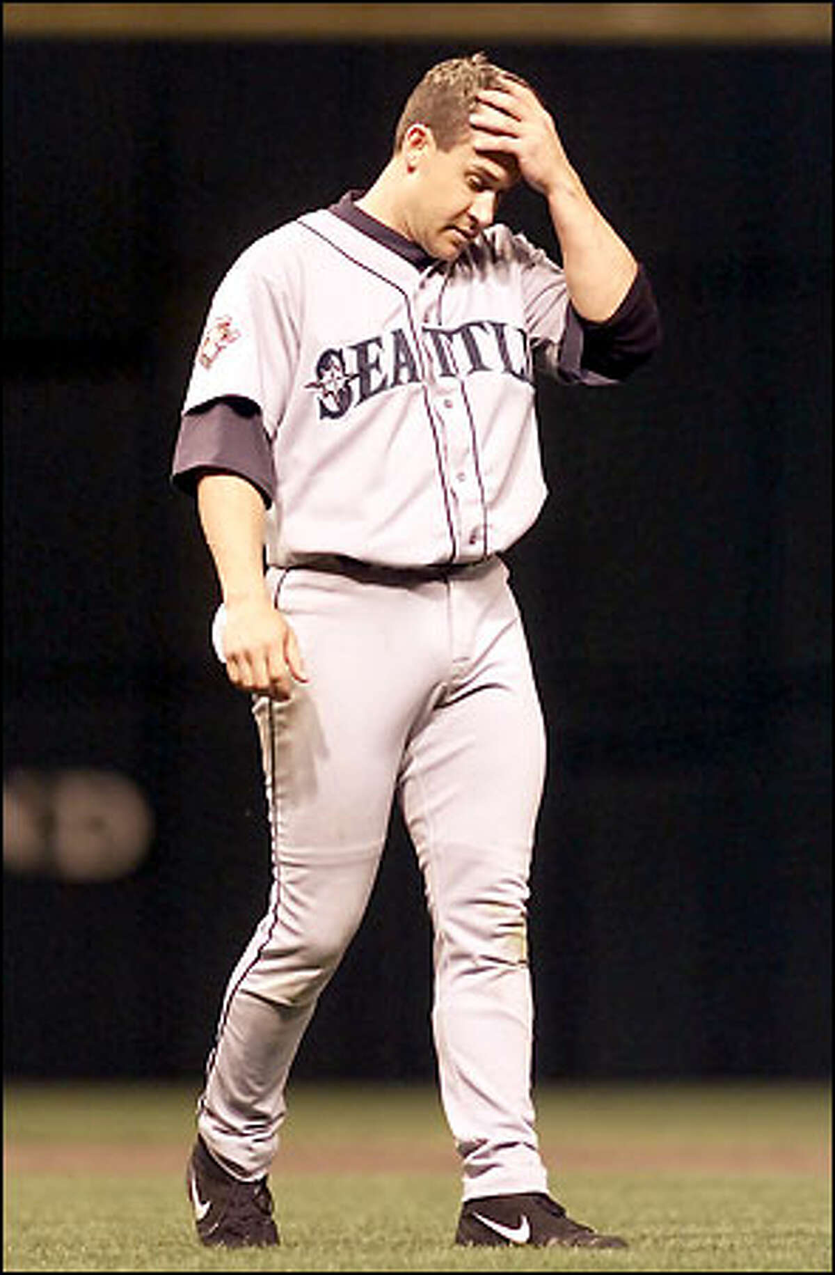 Bret Boone, who struck out swinging four times in his five at-bats, walks back to his position on the field after ending an inning.