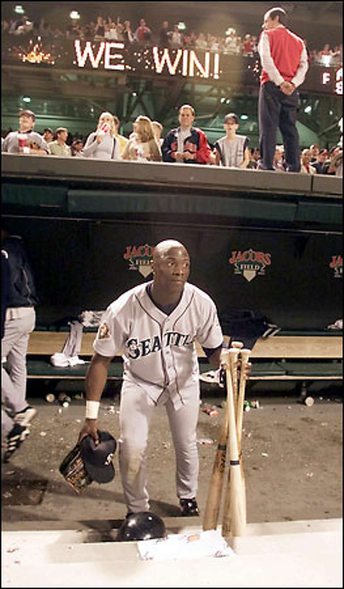 Mike Cameron picks up his bats, glove and hat from the dugout after the Mariners' 17-2 loss to the Cleveland Indians.