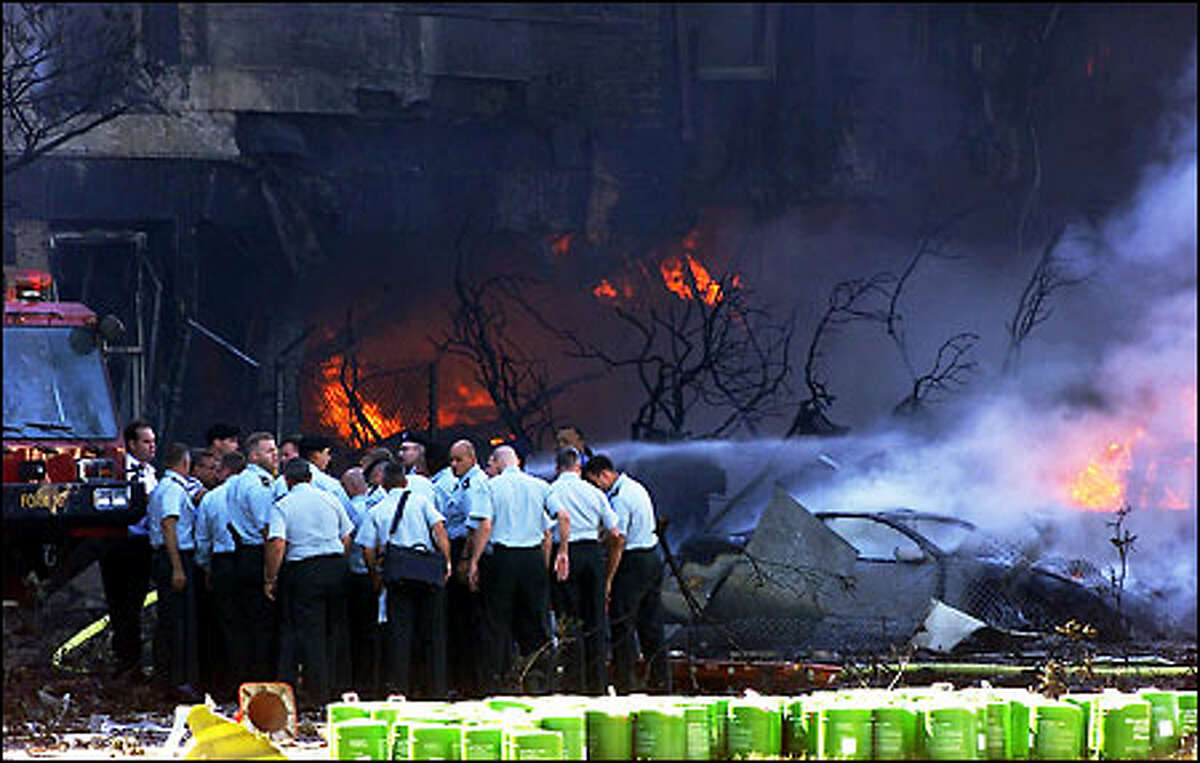 Emergency personnel assess the situation at the Pentagon in Washington after an aircraft crashed into the building on Sept. 11, 2001. (AP Photo/Hillery Smith Garrison)