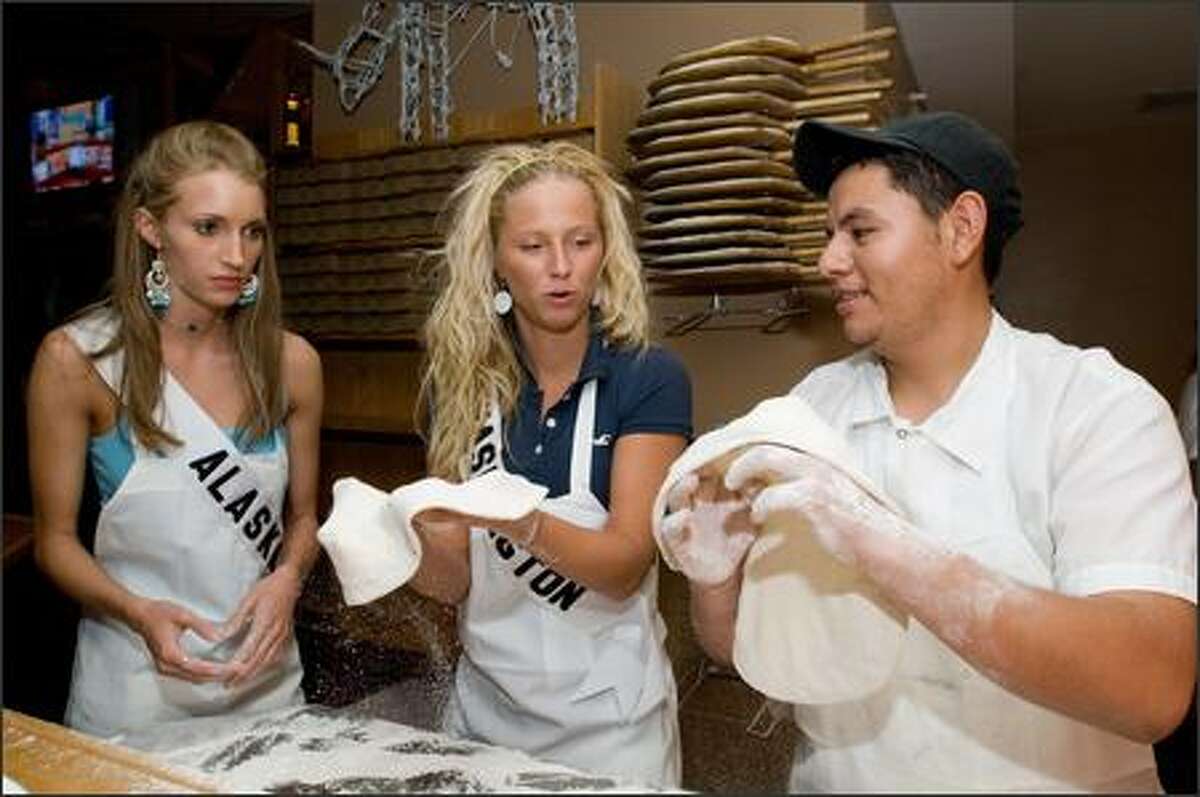 David Garcia shows Degen Kasper, Miss Alaska, and Kendra Lee Timm, Miss Washington, how to work with pizza dough during a pizza bake-off contest at Matchbox restaurant in Palm Springs on Aug. 2.