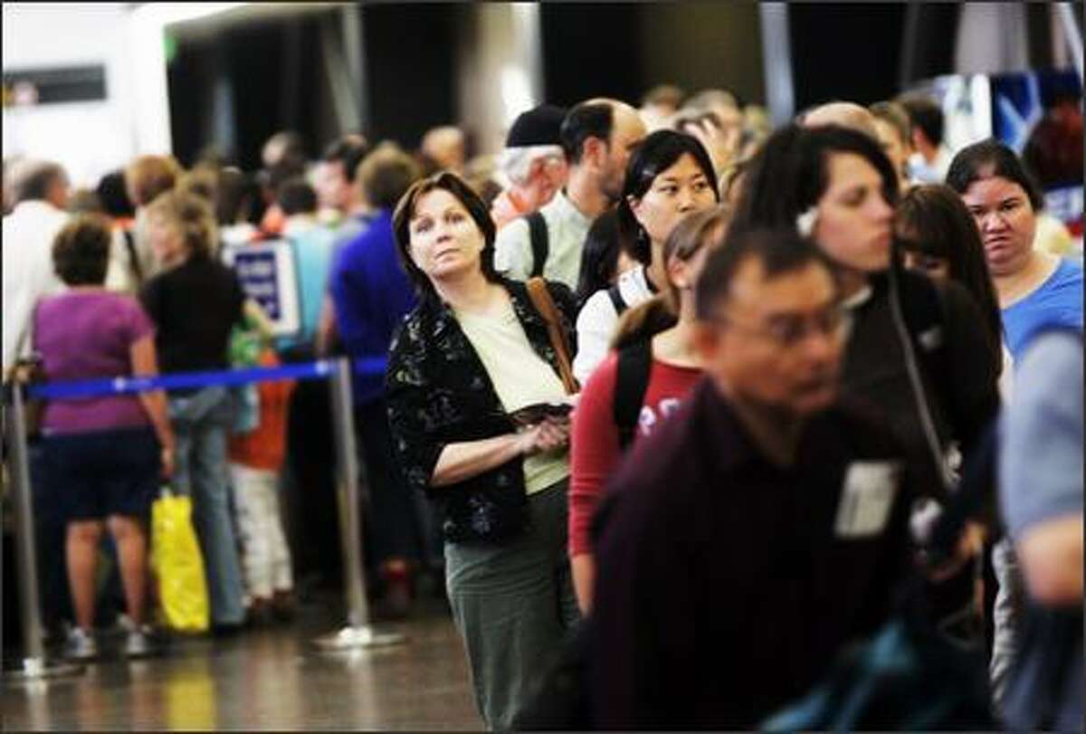 Travelers, including Robyn Dunlap of Dallas, experience long security lines, up to two to three hours, at Sea-Tac Airport.