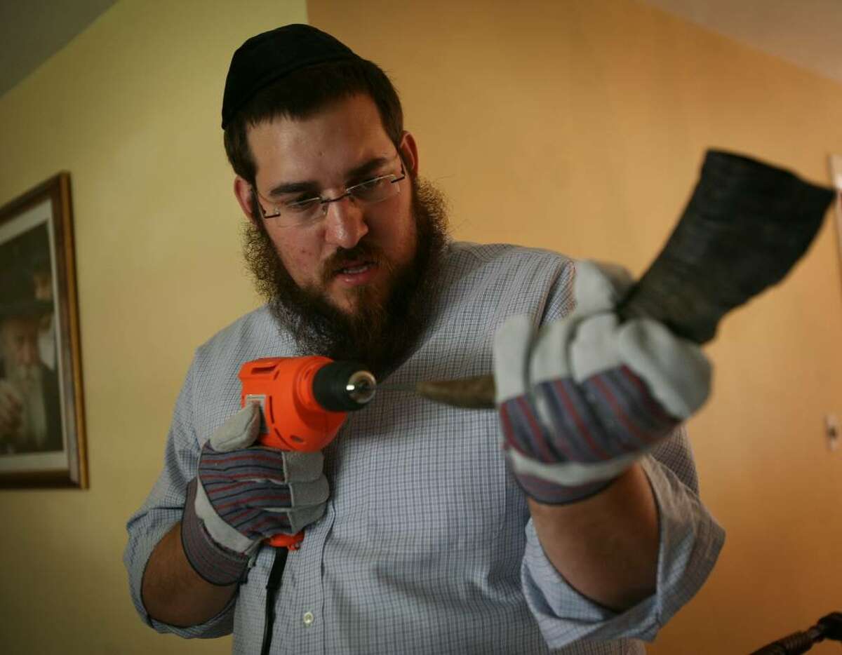 Rabbi Shlame Landa drills through the solid tip of a ram's horn as he demonstrates the making of a Shofar in his home on Thursday, September 10, 2009 in Fairfield, Conn.