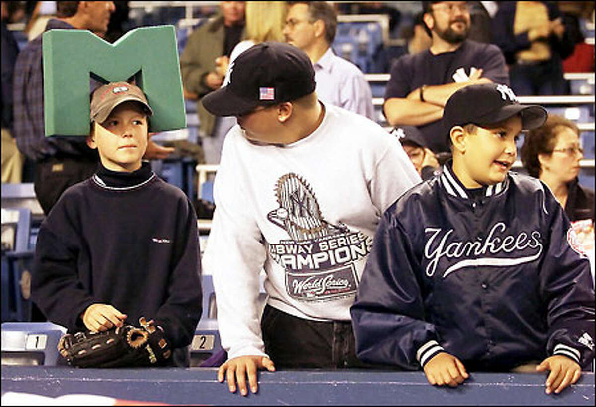 Ten-year-old Freddie Nordhoff , 10, of Bellevue, defiantly wears his brought his "M -Hhead" to at Yankee Stadium next to amid two Yankees fans, Charles Maneri, 12, and his cousin Matt Maneri, 10.