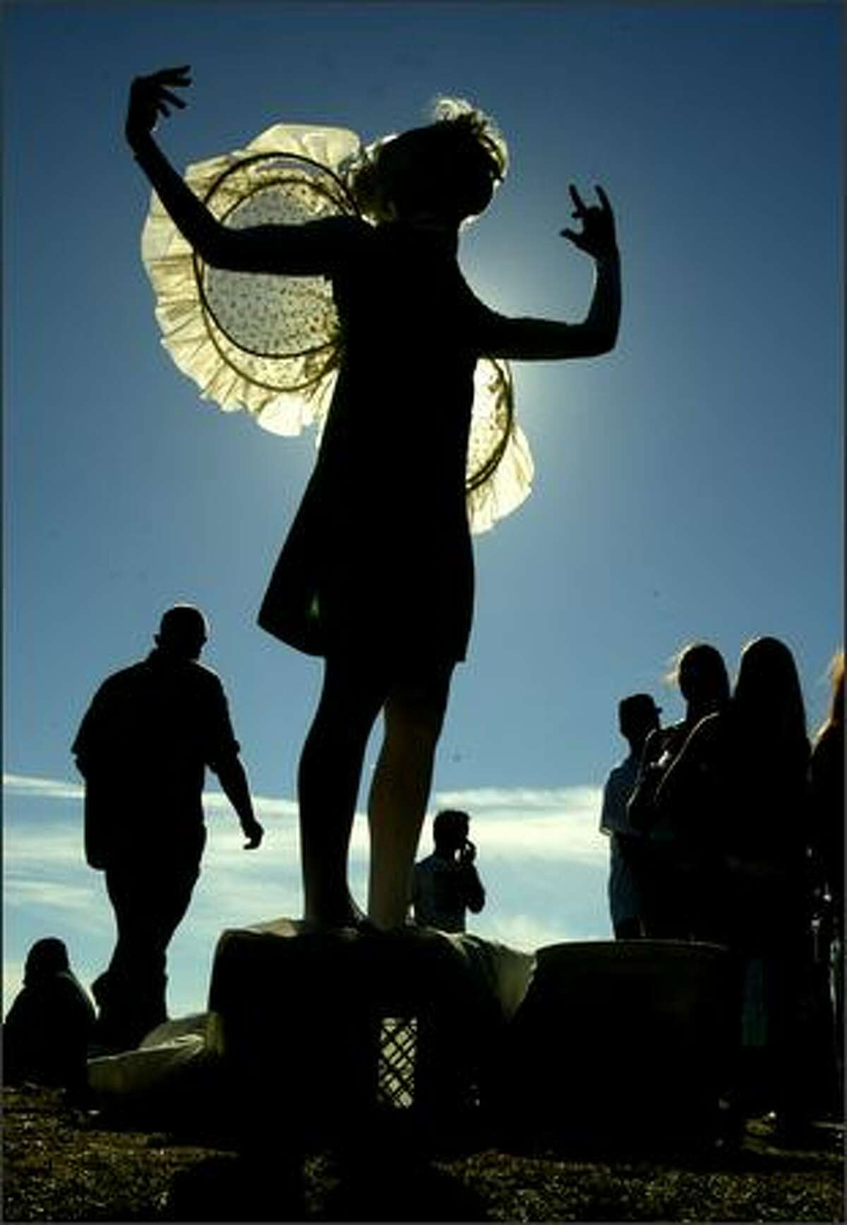 Performance artist Sheri Brown strikes a pose as a human sculpture for spectators attending the 15th annual Hempfest at Myrtle Edwards Park.