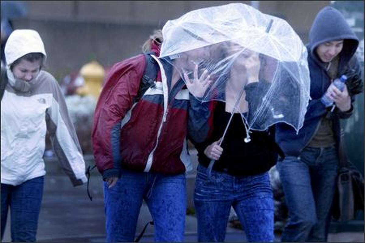 Pedestrians battle wind and rain in the University District.