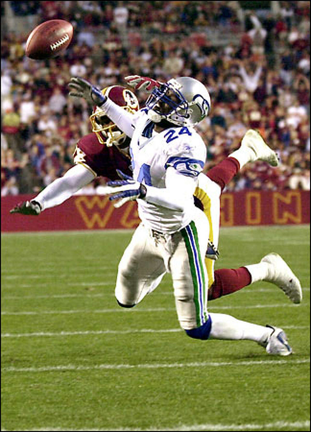 Seahawks cornerback Shawn Springs gets tangled up with Redskins wide receiver Derrius Thompson to break up a second-quarter pass.