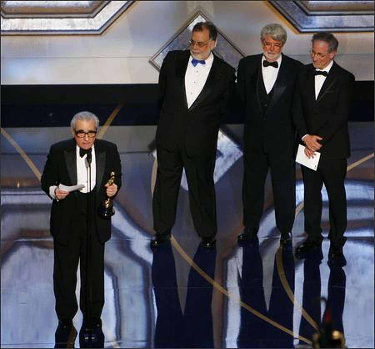Director Martin Scorsese accepts the Oscar for best director for his work on "The Departed" as directors from left, Francis Ford Coppola, George Lucas and Steven Spielberg look on at the 79th Academy Awards Sunday in Los Angeles. (AP Photo/Mark J. Terrill)