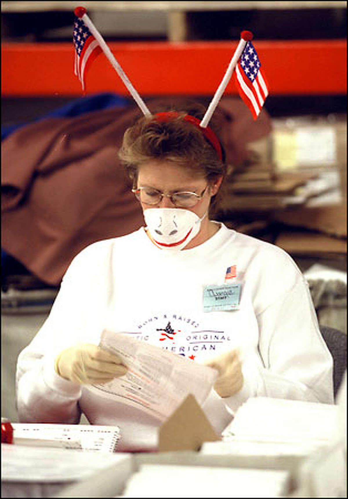 At the Mail Ballot Operation site in South Seattle, Georgia White makes the best out of having to wear a mask and surgical gloves because of anthrax concerns. White and her colleagues were the first to open and inspect mail in ballots for yesterday’s election.